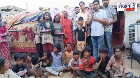Volunteers distributing sweets to slum children during Holi celebration