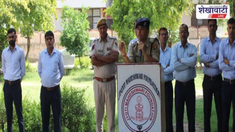 Police officers addressing students on road and cyber safety seminar