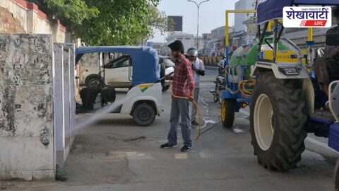 Municipal workers cleaning public toilets using pressure pump in Sikar